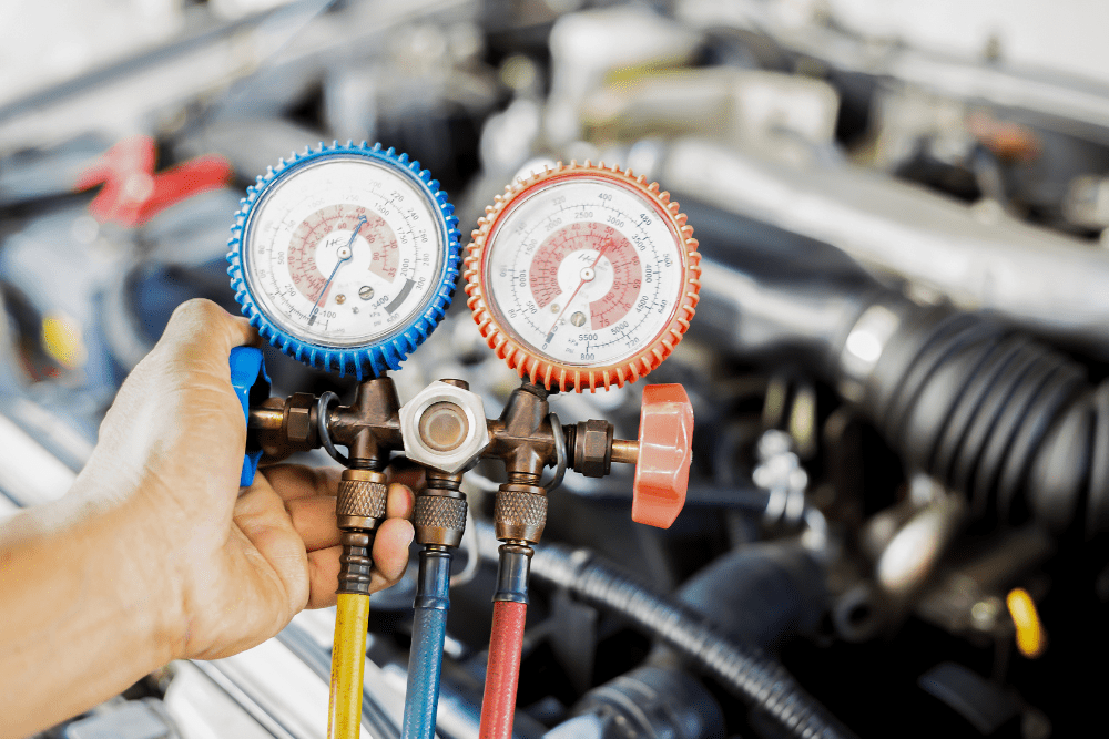 diesel truck a/c repair, diesel repair in Dudley, NC at Archie & Sons Diesel Repair. A close-up of a technician using a manifold gauge set to check refrigerant pressure in a vehicle's air conditioning system.