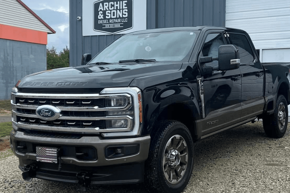 Diesel truck maintenance in Goldsboro, NC by Archie & Sons Diesel Repair. Image of black Ford Super Duty outside repair shop.