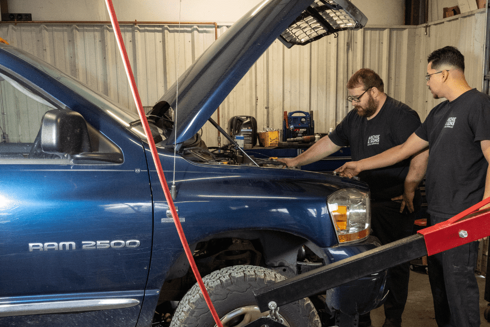 Diesel repair in Smithfield, NC by Archie & Sons Diesel Repair. Image of two technicians inspecting a blue Dodge Ram 2500 with the hood open, emphasizing reliable service to maintain heavy-duty truck performance and safety.